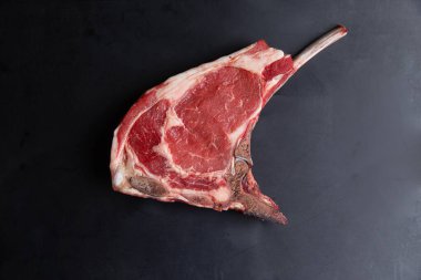 Siyah arka planda klasik çiğ kemik bifteği. Yakın plan.