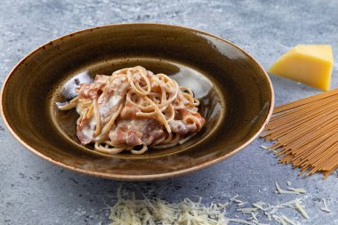 Pastırmalı makarna ve gri bir arka plan.