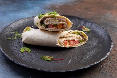 Piita somon ve siyah bir tabakta bitkilerle yuvarlanıyor. seçici odak