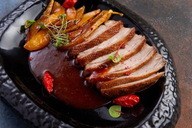 Koyu bir tabakta kızarmış ördek ve karamelize armut. Restoranlar için ideal