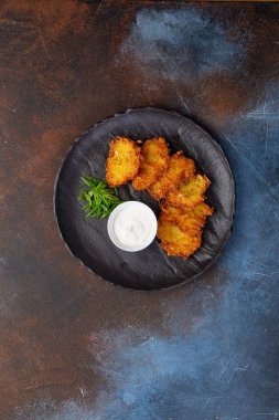 Soslu patatesli krep, geleneksel Ukrayna yemeği. Karanlık bir tabakta