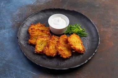 Soslu patatesli krep, geleneksel Ukrayna yemeği. Karanlık bir tabakta