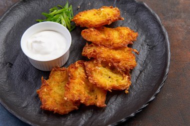 Soslu patatesli krep, geleneksel Ukrayna yemeği. Karanlık bir tabakta