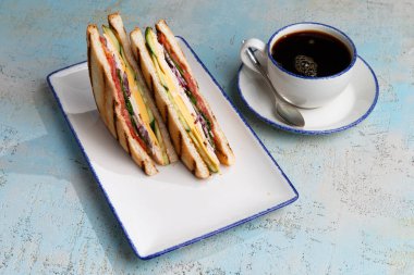 Peynirli sandviç ve tabakta et.