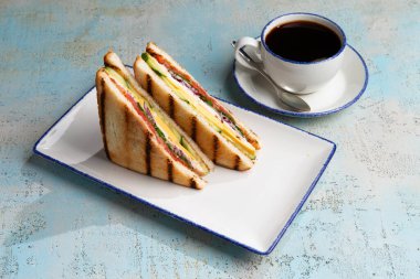 Peynirli sandviç ve tabakta et.