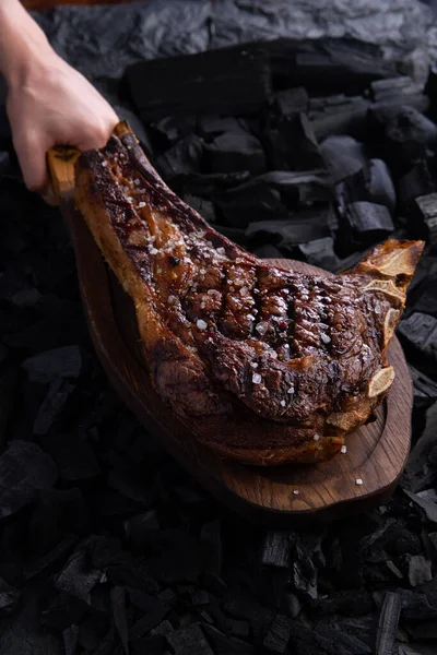 Ready tomahawk steak on a background of coals. Selective focus