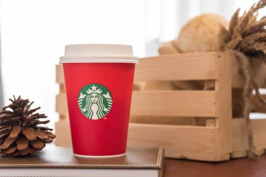 Bangkok, Tayland - 5 Ekim 2016: Kırmızı kağıt mağazalarında ülke Noel için kırmızı arka plan Kupası fincan Starbucks logosu. Starbucks marka ABD'den dünyaca ünlü biridir.