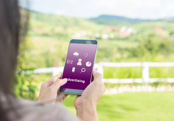 Woman viewing ads on their phones with natural outdoor background.. The concept of advertising.