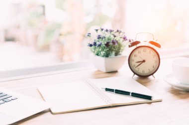 Üstünde pencere sabah ışık ile defter kalem ile çalışıyor.