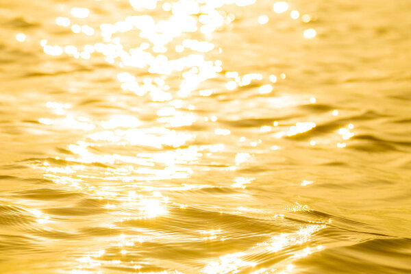 Abstract Solar reflective surface gold background. Bokeh effect. Smooth light gold waves lines and Lens Flares.
