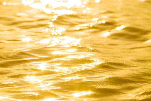 Abstract Solar reflective surface gold background. Bokeh effect. Smooth light gold waves lines and Lens Flares.