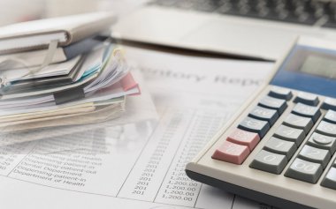 Muhasebe iş kavramı. Hesap makinesi muhasebesi raporu ve mali tablo üstünde okul sırası ile.