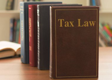 Tax Law books on desk in the law firm. legal education concept. clipart