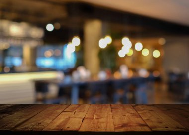Kafe restoranının soyut arka planına sahip boş ahşap masa, Bokeh light arka planlı kahve dükkanı. -... ürünlerinizi sergilemek için kullanılabilir..