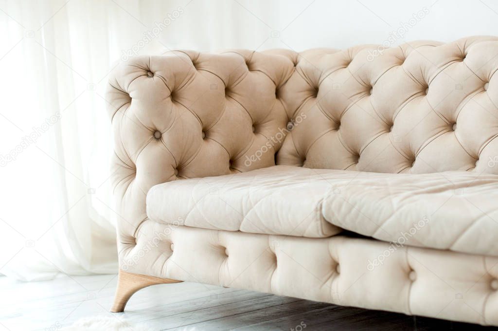fragment of a beige sofa with buttons 