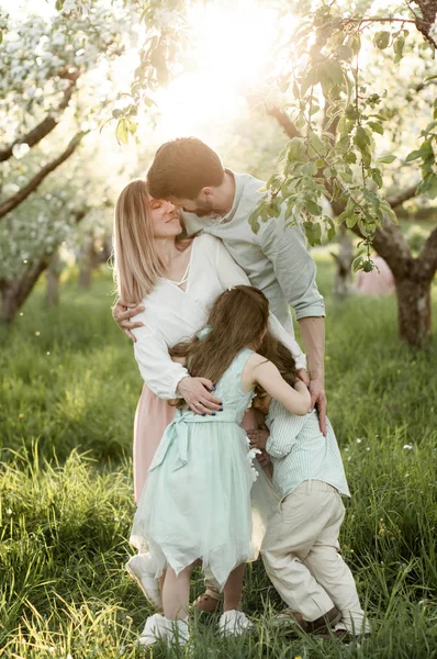 Giovane Bella Famiglia Con Due Bambini Che Abbracciano Giardino Fiorito — Foto Stock