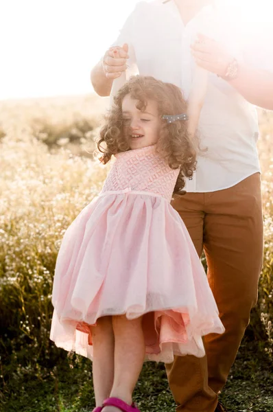 Vader Een Klein Meisje Met Krullend Haar Swingend Roze Jurk — Stockfoto