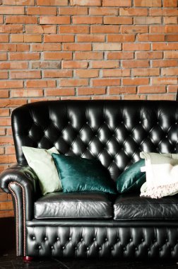 Tuğla duvar karşısında siyah deri kanepe ile Loft iç