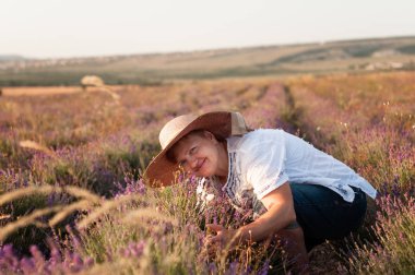 Gün batımında bir tarlada lavanta toplama hasır şapka orta agged kadın