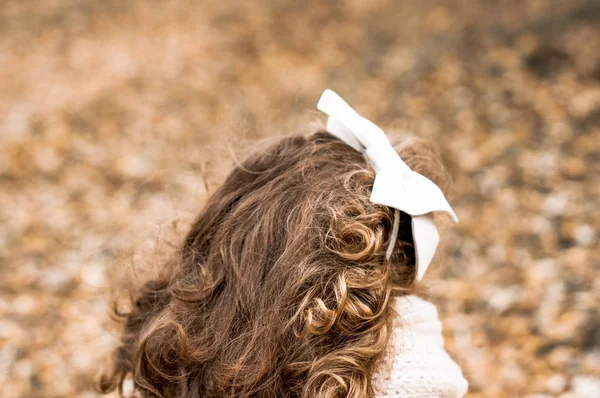 Милая Маленькая Девочка Вьющимися Волосами Белым Луком Радуется Осенью — стоковое фото