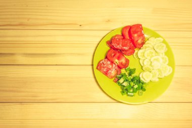 Ahşap bir tabakta birkaç dilim sebze.