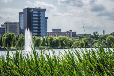 Yazın bulutlu bir gününde Gheorgheni mahallesindeki bir göl kıyısından Cluj Napoca 'da yapılan fantastik şehir manzarası