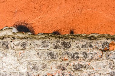 Aşınmış turuncu duvar dokusuna tuğlalarla yakın çekim.