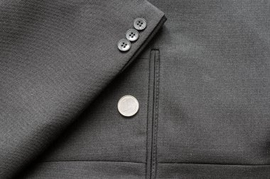 Bir iş elbisesinin birkaç düğmesini kapatıyorum. Bir Euro bozukluk.