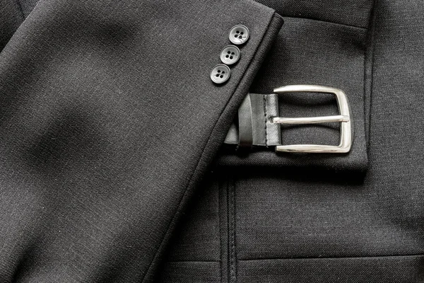 Close up of a few buttons on a business suit coat and a leather belt