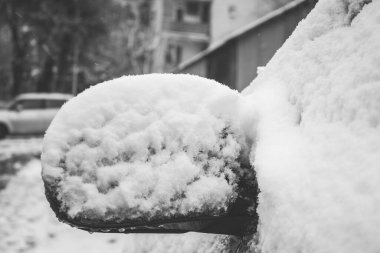 Bir arabanın yan aynasında kar.