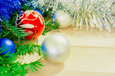 Noel arkaplanı, çam ağacı dalları, süslemeler ve ahşap tahtada takılar.