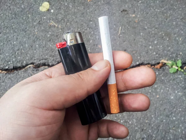 Kézzel Könnyebb Cigaretta Sötét Aszfalt Háttér — Stock Fotó