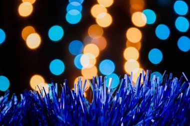 Noel arkaplanı, çam ağacı dalları, hediyeler ve mavi ve sarı ışıklı çam kozalakları. Renkli mücevherler, mavi tatil süslemeleri.