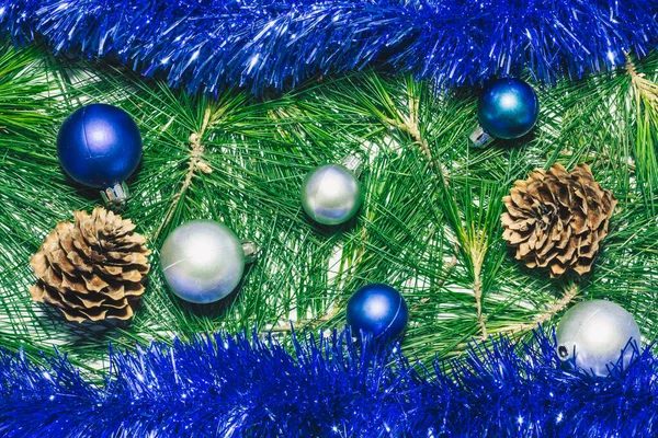 松ぼっくり 青の装飾 クリスマスボールと緑の松の葉を持つX Masの背景 — ストック写真