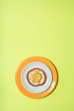 Beyaz ve turuncu tabakta kırmızı biber dilimi yeşil renkli arka planda. Bir broşür, pankart, kapak ya da broşür tasarımı için dikey tasarım