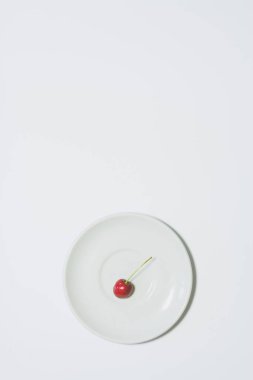 Minimum vişne arkaplanı. Beyaz tabakta meyve. Bir broşür, pankart, kapak veya broşür için dikey tasarım