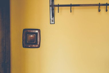 Arka planda elektrik düğmesi ve sarı duvardaki ev askısından yapılmış. Vintage mat rengi