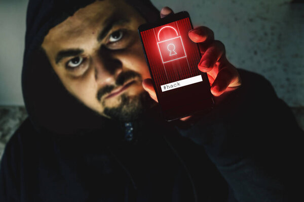 Разъяренный хакер держит телефон с черным экраном. Предупреждение кибератаки. Концепция Ransomware
