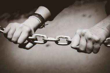 Paslanmaz çelik zincirin üzerinde genç bir el. Gençlik sorunları konsepti. Kavramsal resim