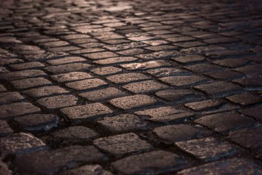 Geceleri parke taşıyla aydınlatılmış ıslak asfalt yol