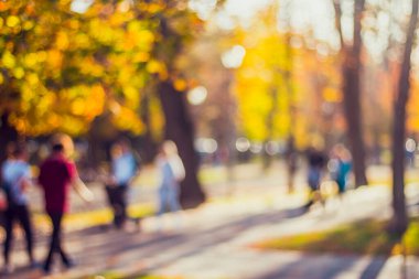 Central Park 'ın arka planı bulanık. İnsanlar aileleriyle yürüyor.