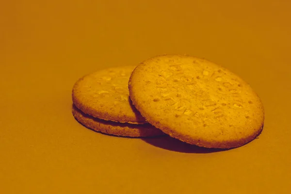 褐色背景上的两个圆形的消化饼干堆在另一个上面 — 图库照片