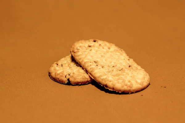 两个长长的圆角消化饼干 一个放在一张褐色的纸上 上面有碎屑 — 图库照片