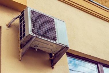 Metalik ızgarası olan büyük beyaz klima, evlerde bulunan soğutma ünitesini rahatlatmak için kullanılan elektrikli ve modern bir cihazın üzerine yerleştirilmiş.