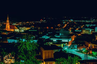 Caddelerdeki parlak renkli ışıklar ve hız izleri Cluj Napoca Romanya 'nın parlak şehir manzarasını fütüristik gelişim için kavramının yukarısından gösteriyor. Geceleri Transilvanya