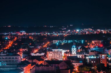Şehir binaları ve caddeleri yoğun parlak renklerle kaplı. Şehir mimarisinin neon ışıklarıyla manzarası. Metropol, seyahat ve turizm için görüntü kavramı.