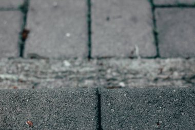 Kare gri kaldırım bloğu, pürüzlü bir yüzeyi var. Farklı yapıların yapımında kullanılan katı madde. Geçitler ve sokaklar için dekoratif taş küp