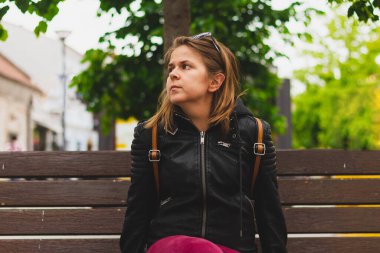 Parktaki bankta oturan kısa kahverengi saçlı, genç ve güzel bir kadın. Mutlu kız hayal kuruyor ve doğada tek başına vakit geçiriyor.