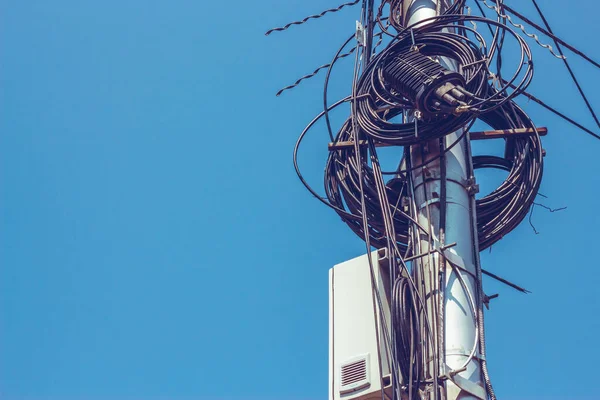 Telefon kabloları şehirdeki beton bir sütunun üstünde kopyalanmış. Bir sütuna yerleştirilmiş veri transferi için kullanılan elektrik kabloları. Yüksek voltaj ekipmanları