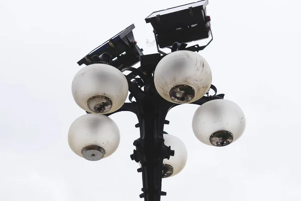 复古街灯 球状灯泡和灯光投影仪放置在锻造的金属柱子上 日照时古色古香的电气照明 — 图库照片